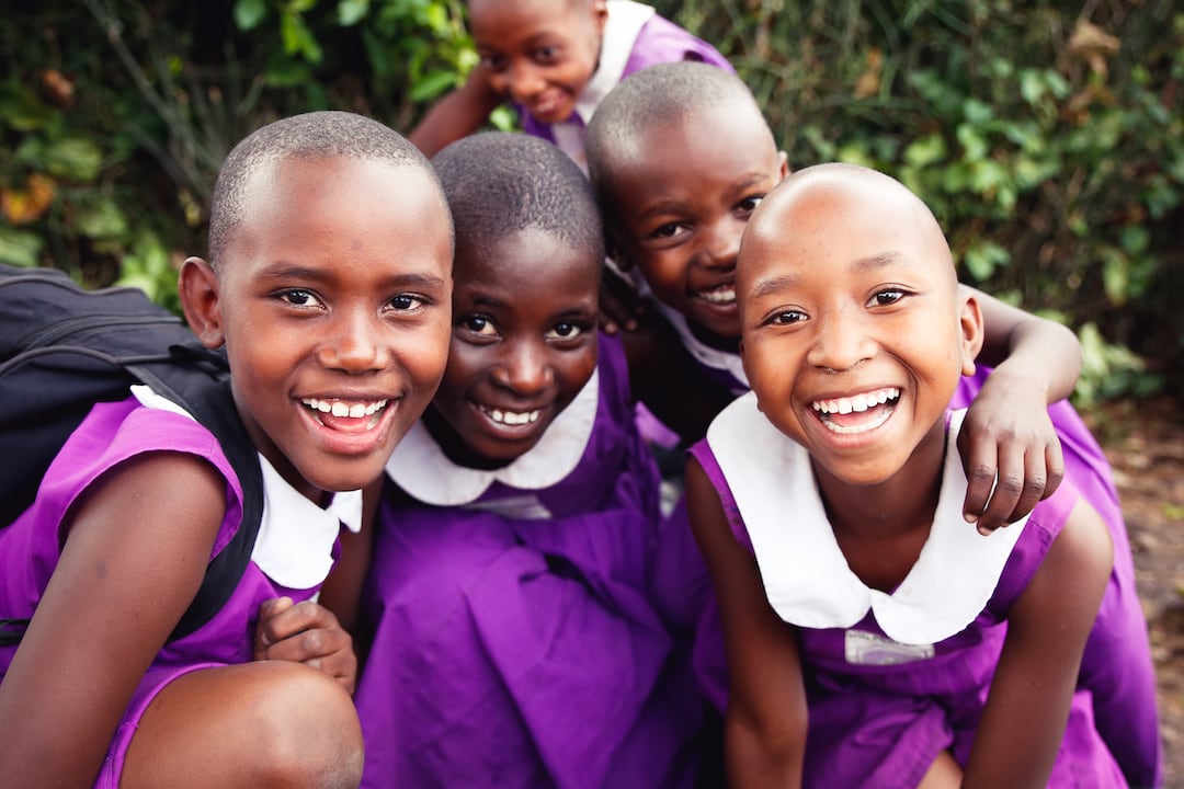 Group of young Ugandan primary student girls in their purple Nyaka uniforms.