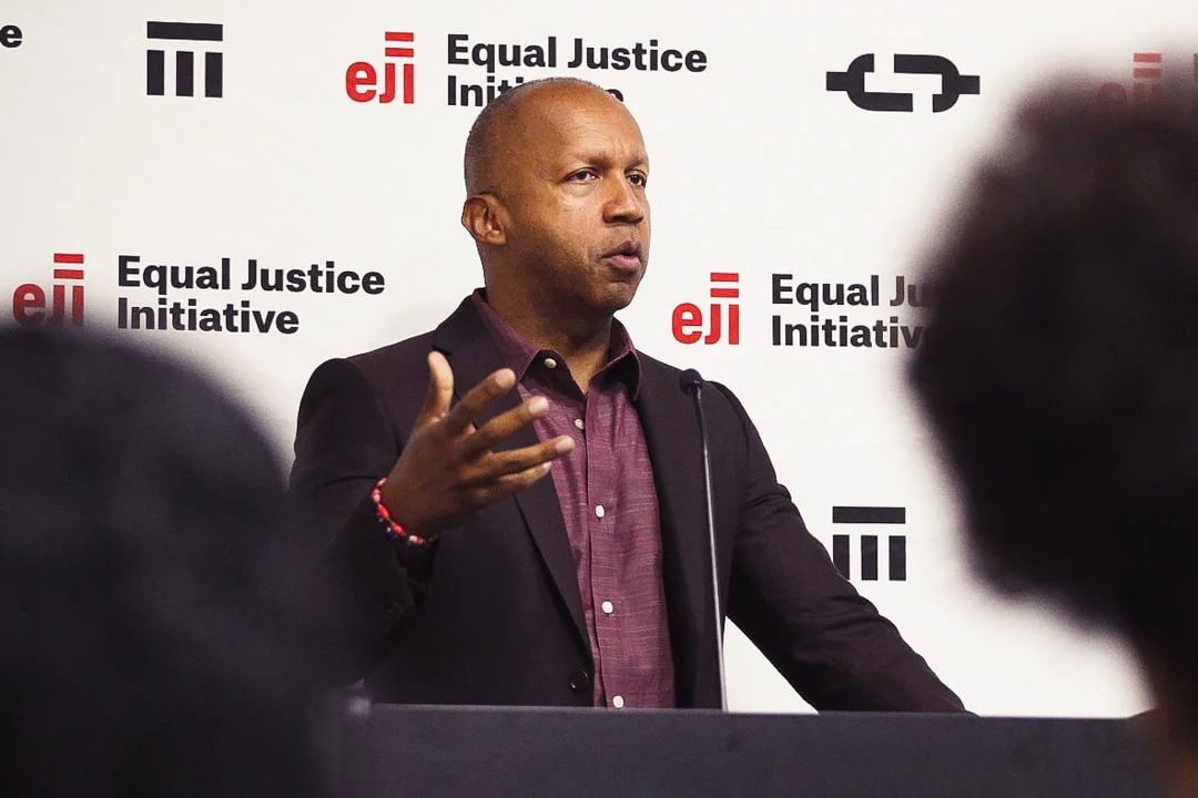 Author and Equal Justice Initiative leader Bryan Stevenson standing at a lectern addressing media.