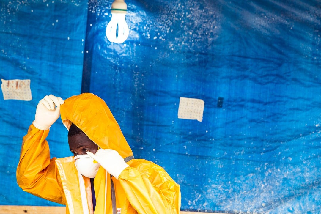 Male Liberian health worker wearing a yellow hazmat suit and mask during the Western African Ebola epidemic of 2013-2016.