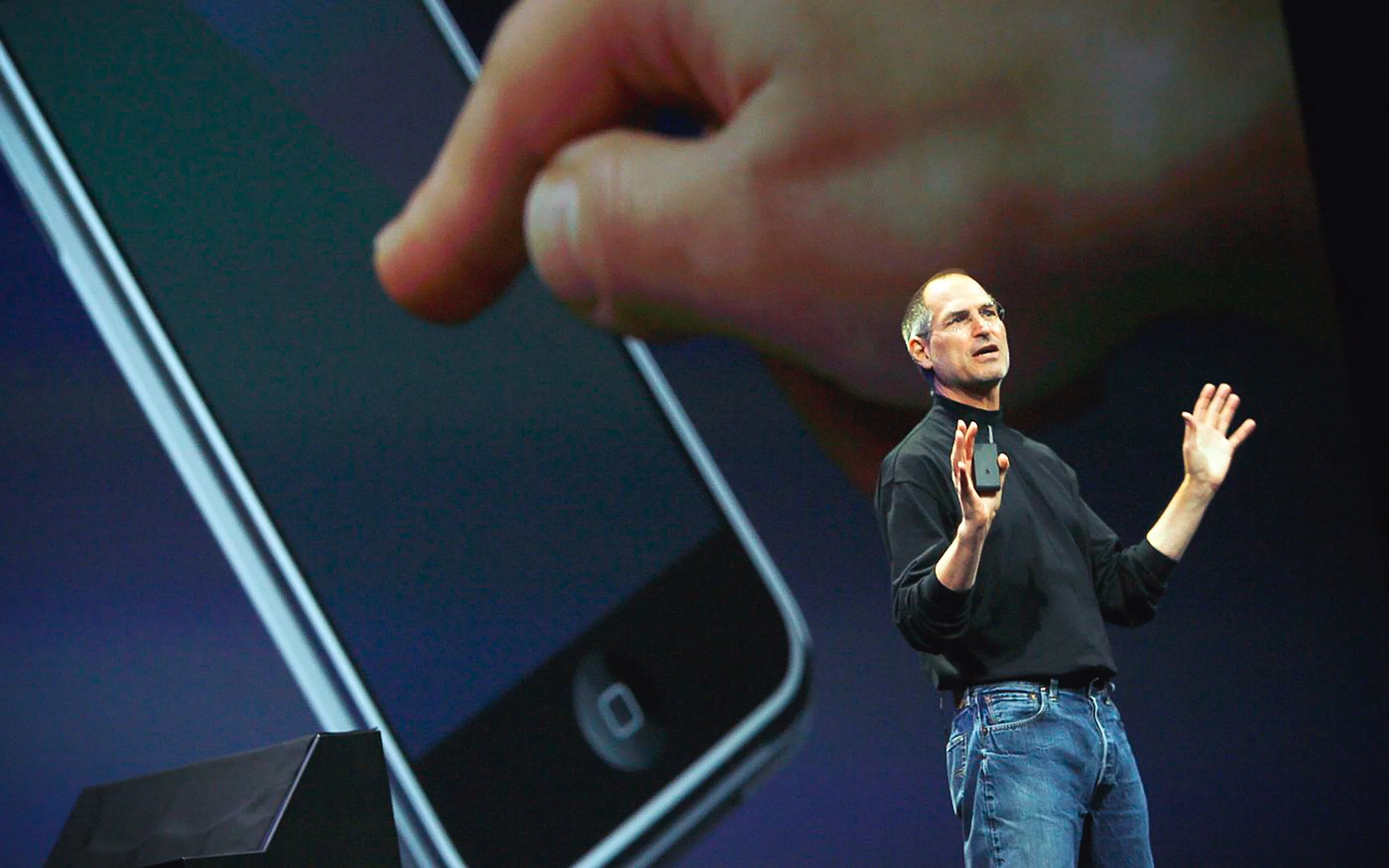 Steve Jobs standing on stage addressing a crowd about a new Apple product