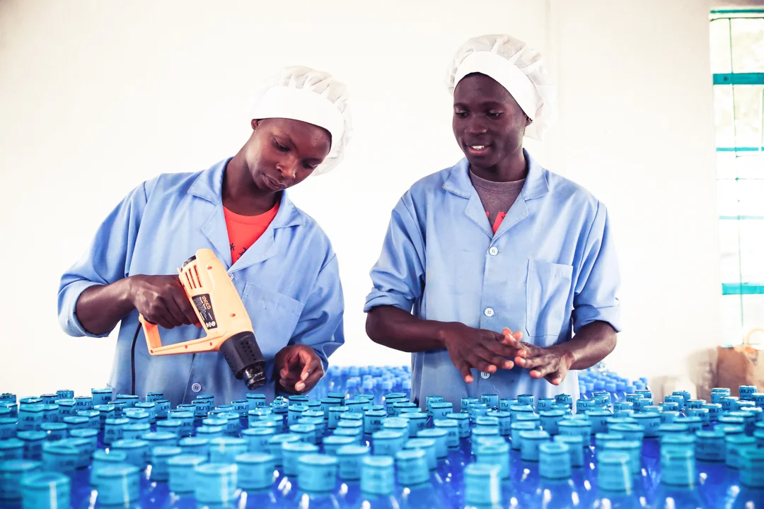 Ubuntu Life team members sealing bottles of water co-branded with Java House of Kenya.