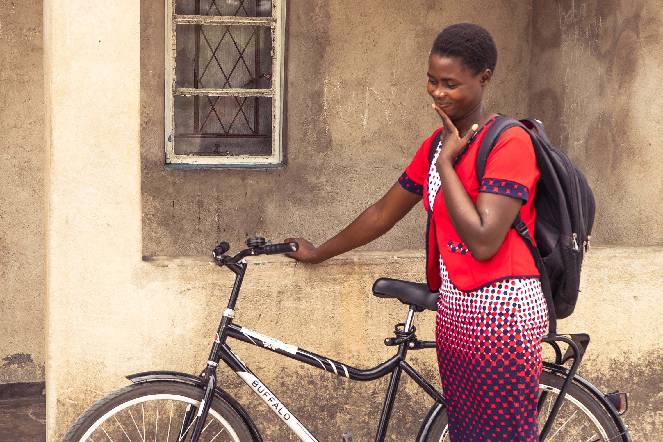 African woman standing with her bicycle.